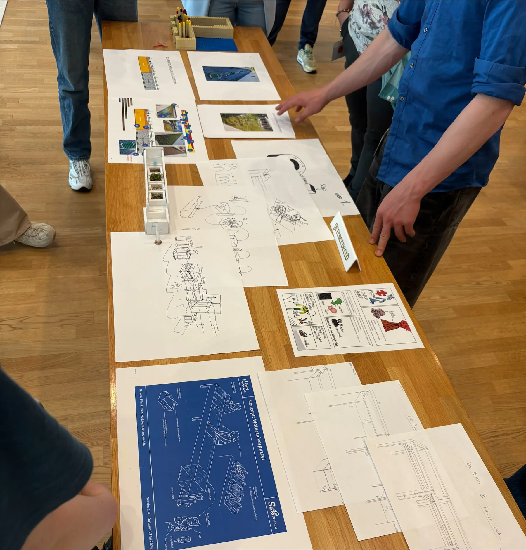 Interactief ontwerp van leerlingen waarin water via een tafel langs verschillende onderdelen stroomt en zo stap voor stap op natuurlijke wijze wordt gezuiverd.